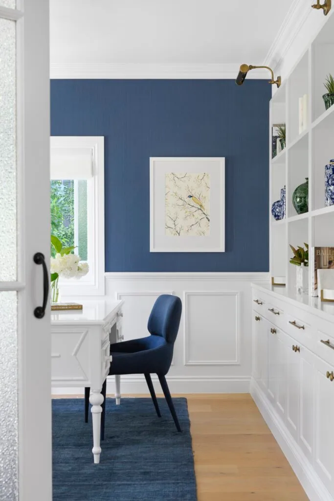 A blue and white home office with wainscoting.