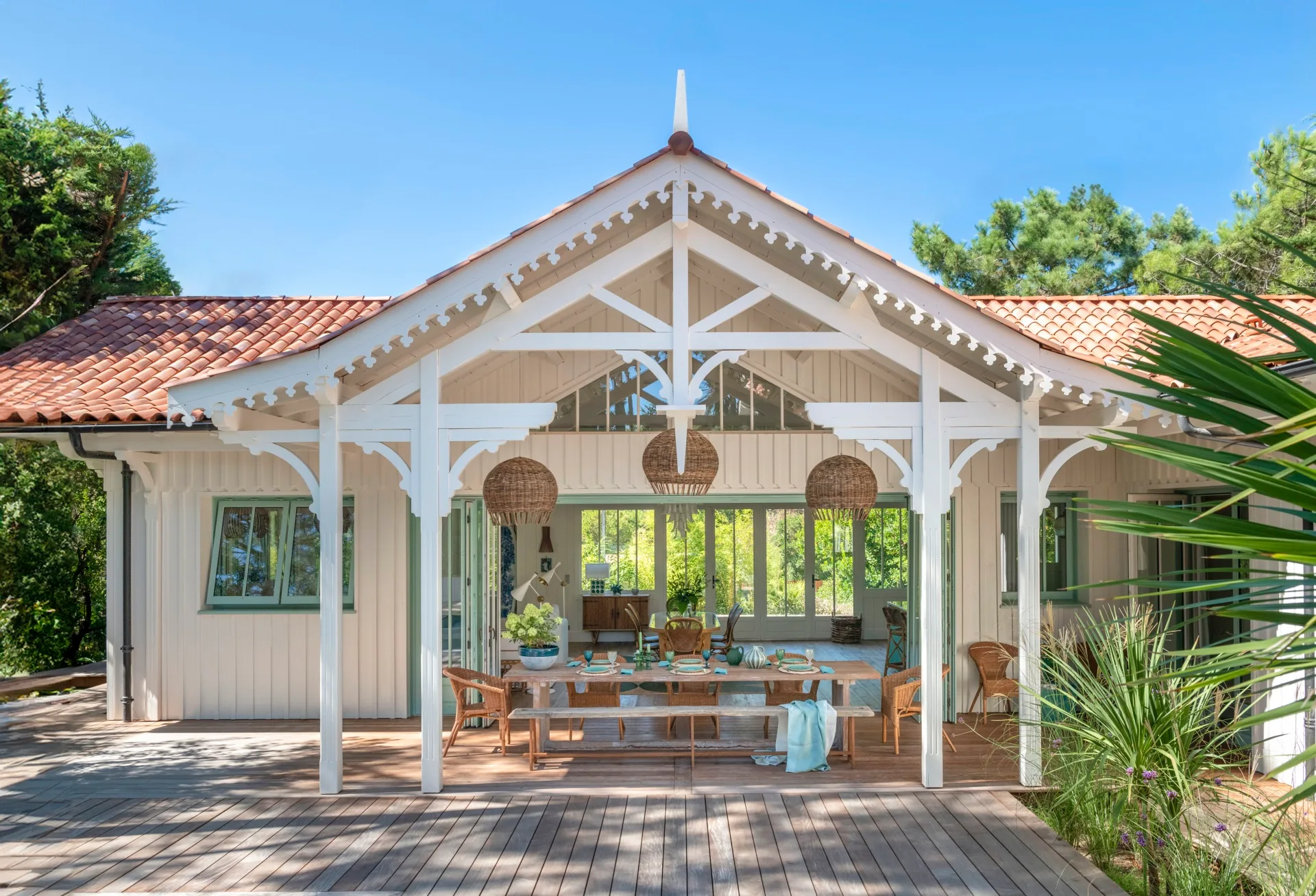 An alfresco area covered by a pitched roof with decorative wood details.