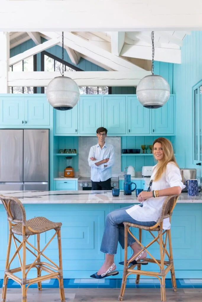 A coastal-style kitchen with blue panelling and owner Deborah and son Lachlan.