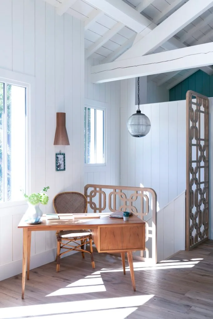 A study nook with a timber desk and wicker chair.