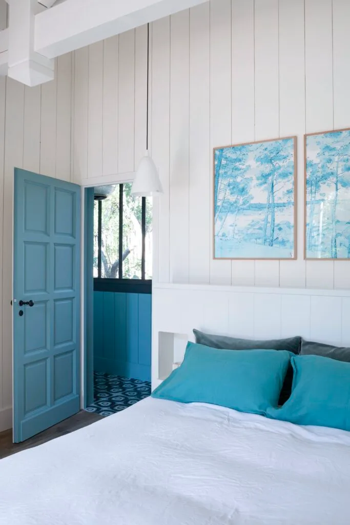 A coastal blue and white bedroom with panelled walls.