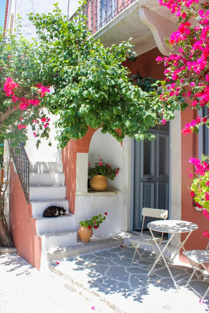 A peach-coloured villa with steps to a balcony in Greece.