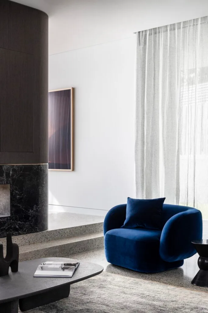 A modern living room with a curved blue armchair.