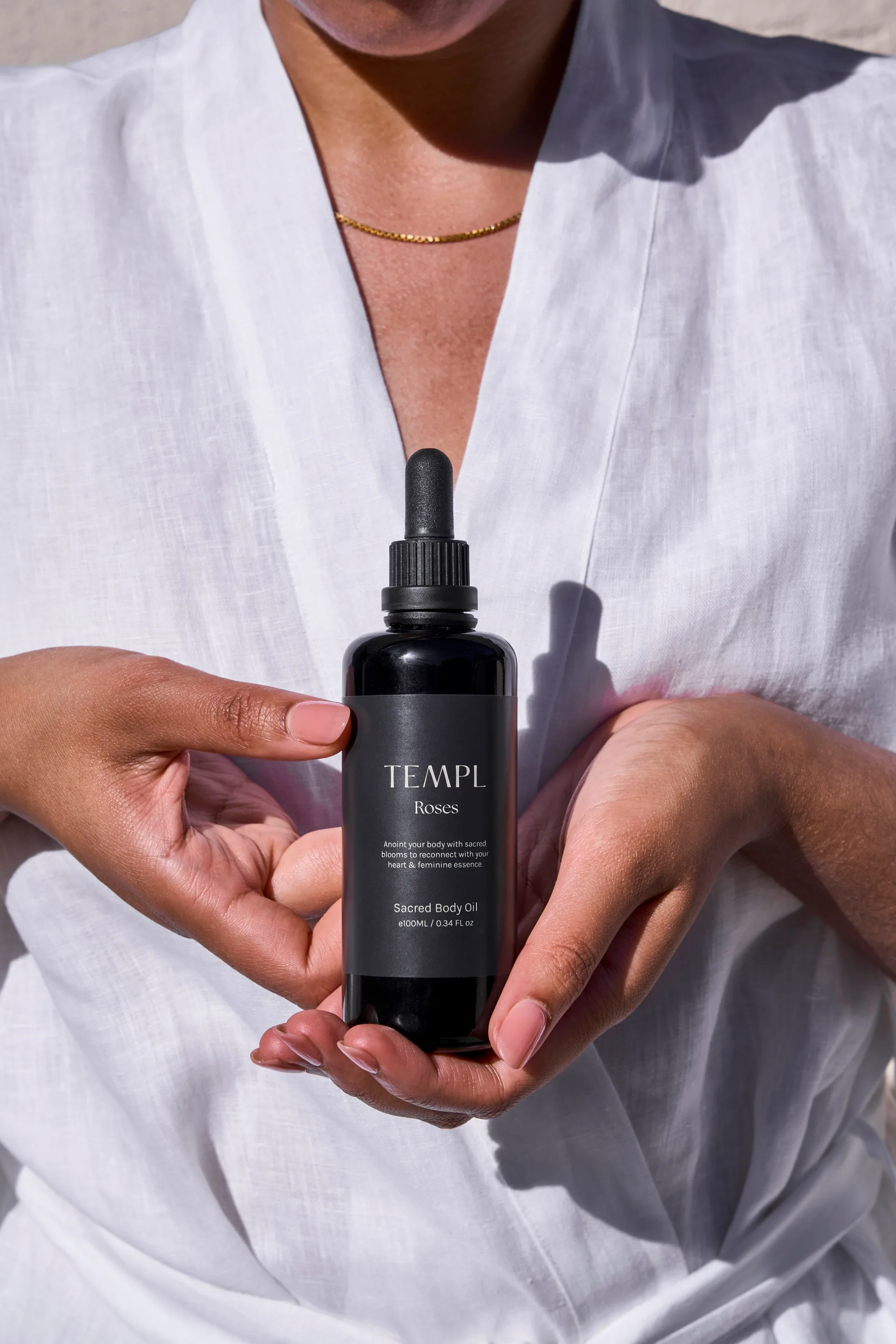 Hands holding a black Templ bottle.