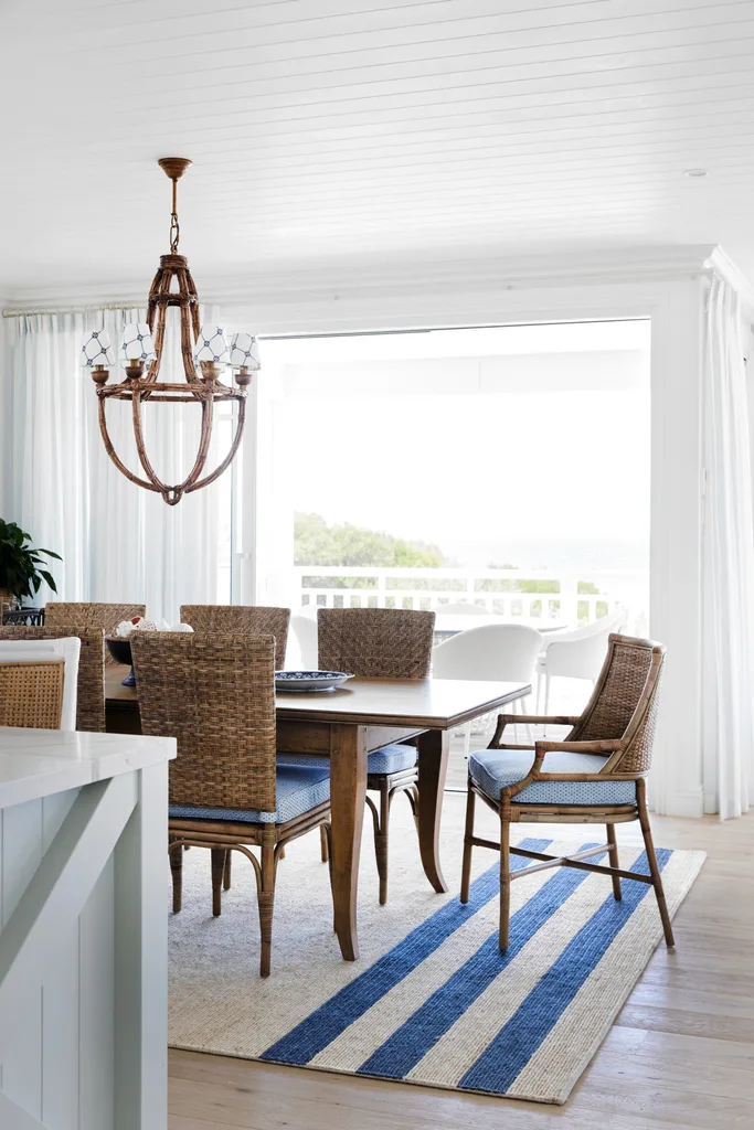 A cream rug with thick blue stripes is placed beneath the dining table and chairs.