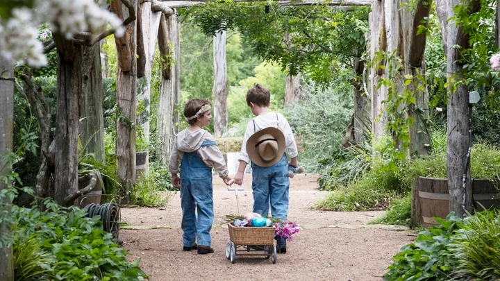 Easter Egg Hunt Children Pulling Cart Under Archway