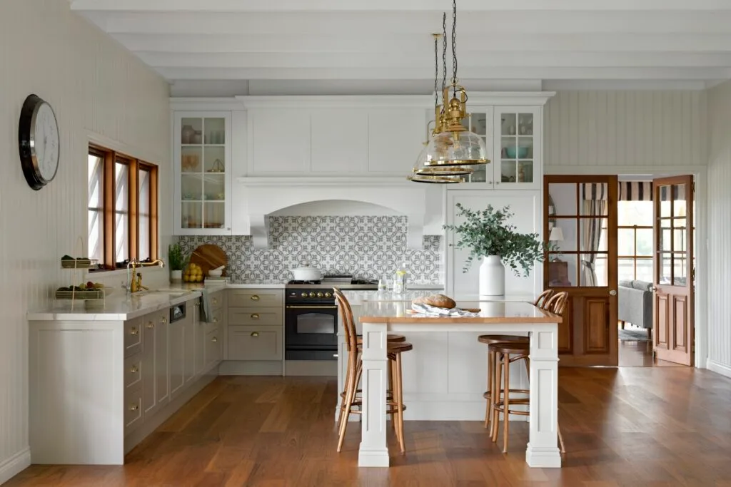 A country kitchen with blackbutt timber floors, a timber topped table and brass accents.