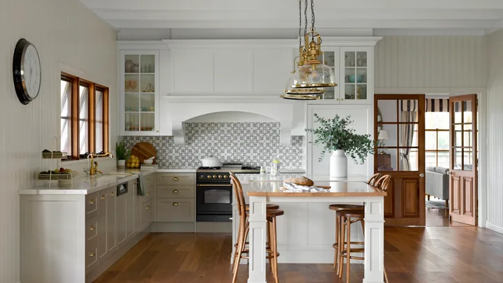 A country kitchen with blackbutt timber floors, a timber topped table and brass accents.