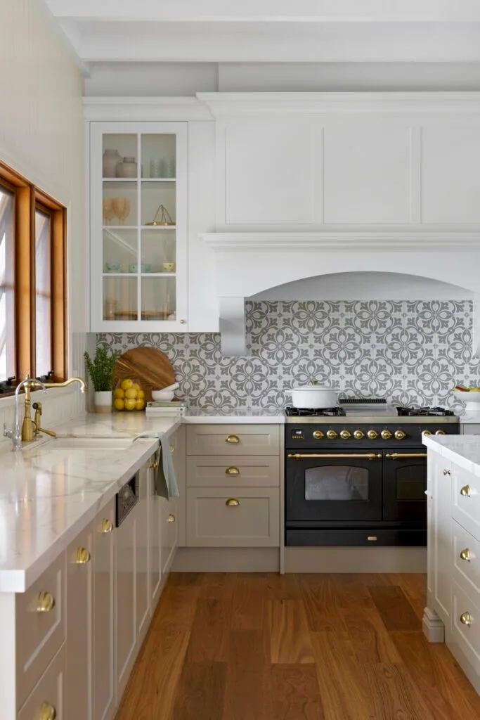 A country kitchen with grey shaker style cabinets and a mosaic splashback.