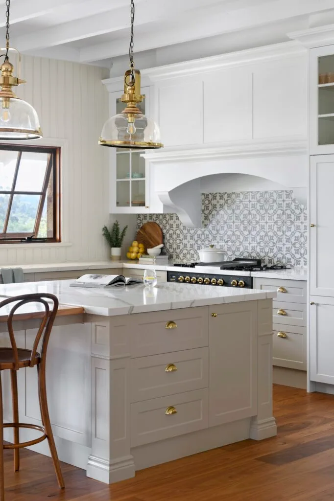 A marble topped kitchen island with shaker style panels.