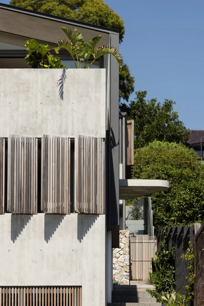 A two-storey home with slatted timber window shades.