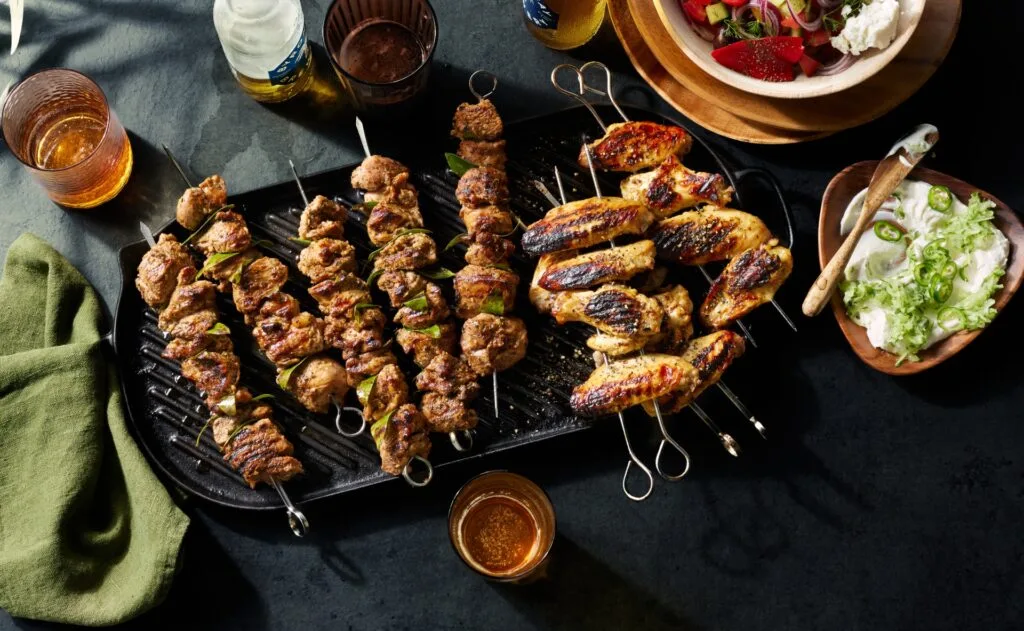 A tray of lamb skewers and grilled chicken wings.