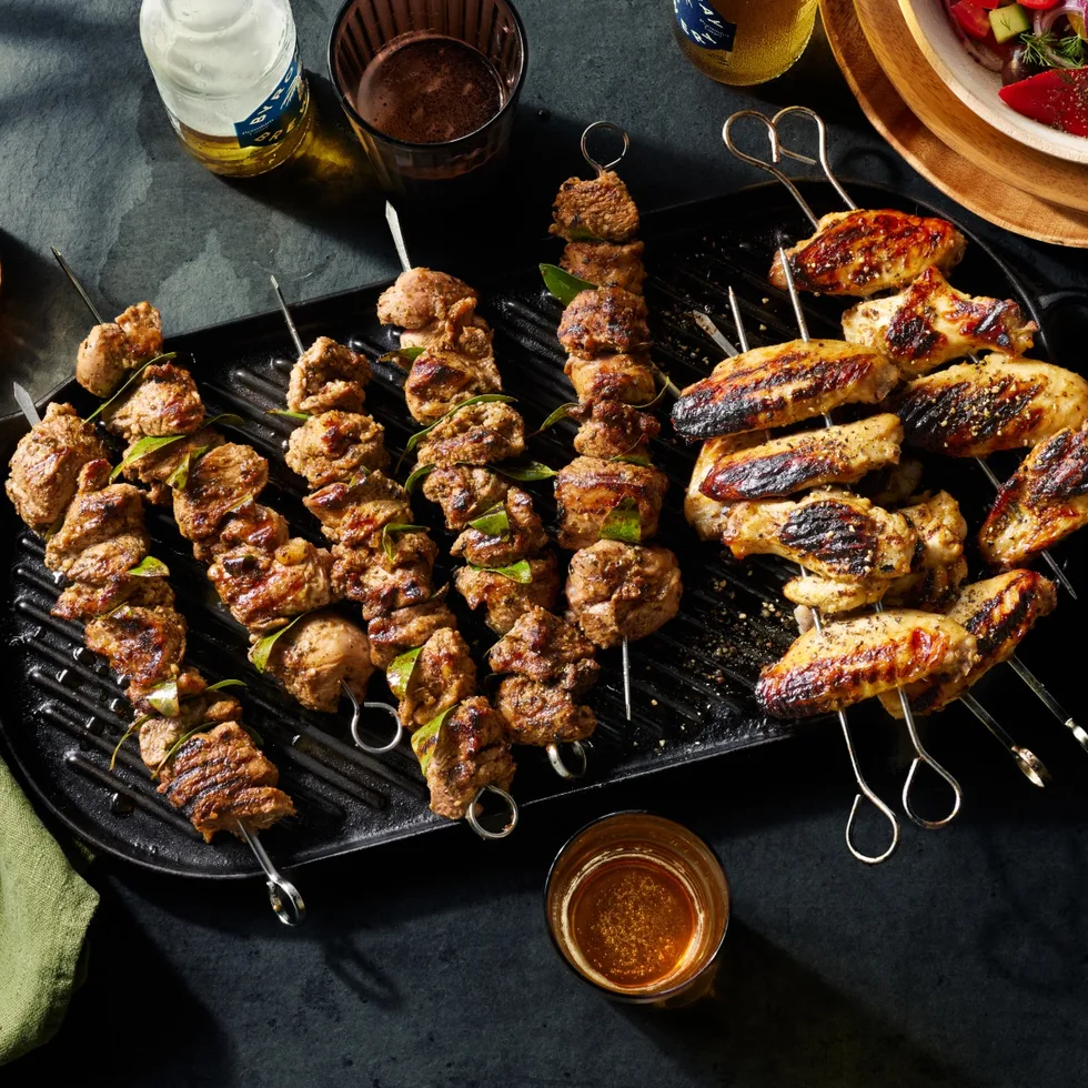A tray of lamb skewers and grilled chicken wings.