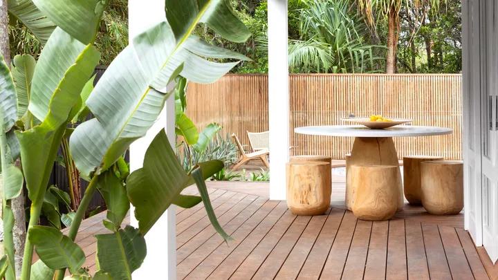 Alfresco area of Byron Bay wabi sabi style home with timber outdoor dining table and chairs