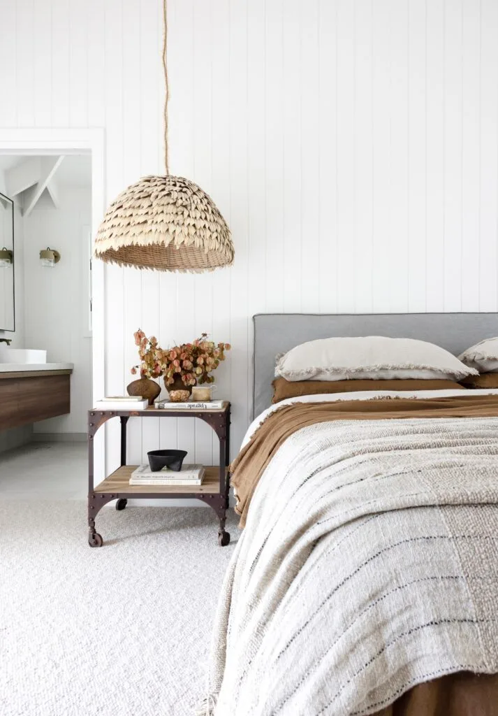 An all-white panelled bedroom with minimalist, coastal decor.