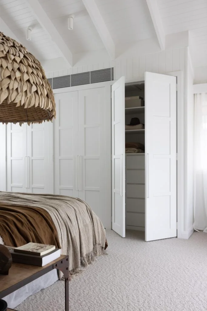 An all-white bedroom with a built-in panelled robe.