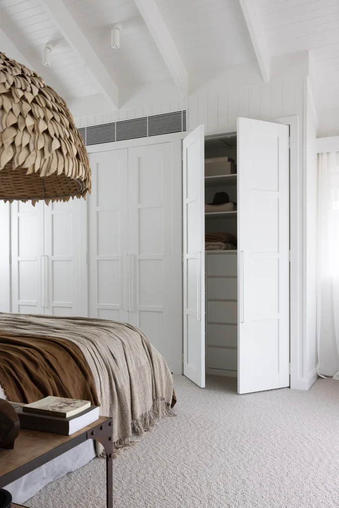 An all-white bedroom with a built-in panelled robe.