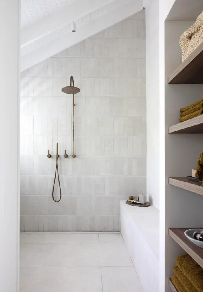 A neutral ensuite with a shower and shower bench.