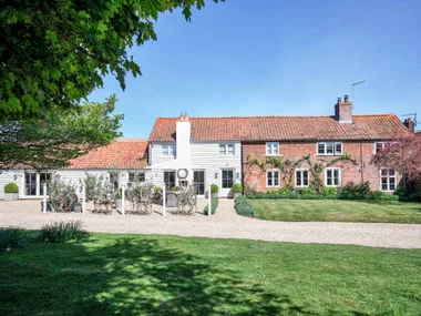 A weatherboard and brick country cottage with an outdoor alfresco area.