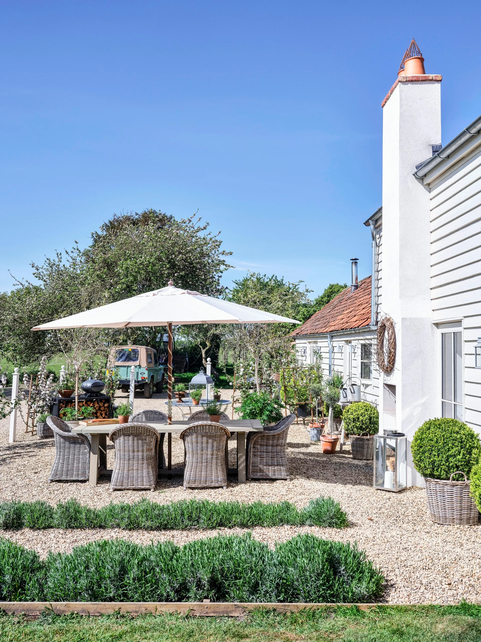 A white country cottage with an outdoor seating area.