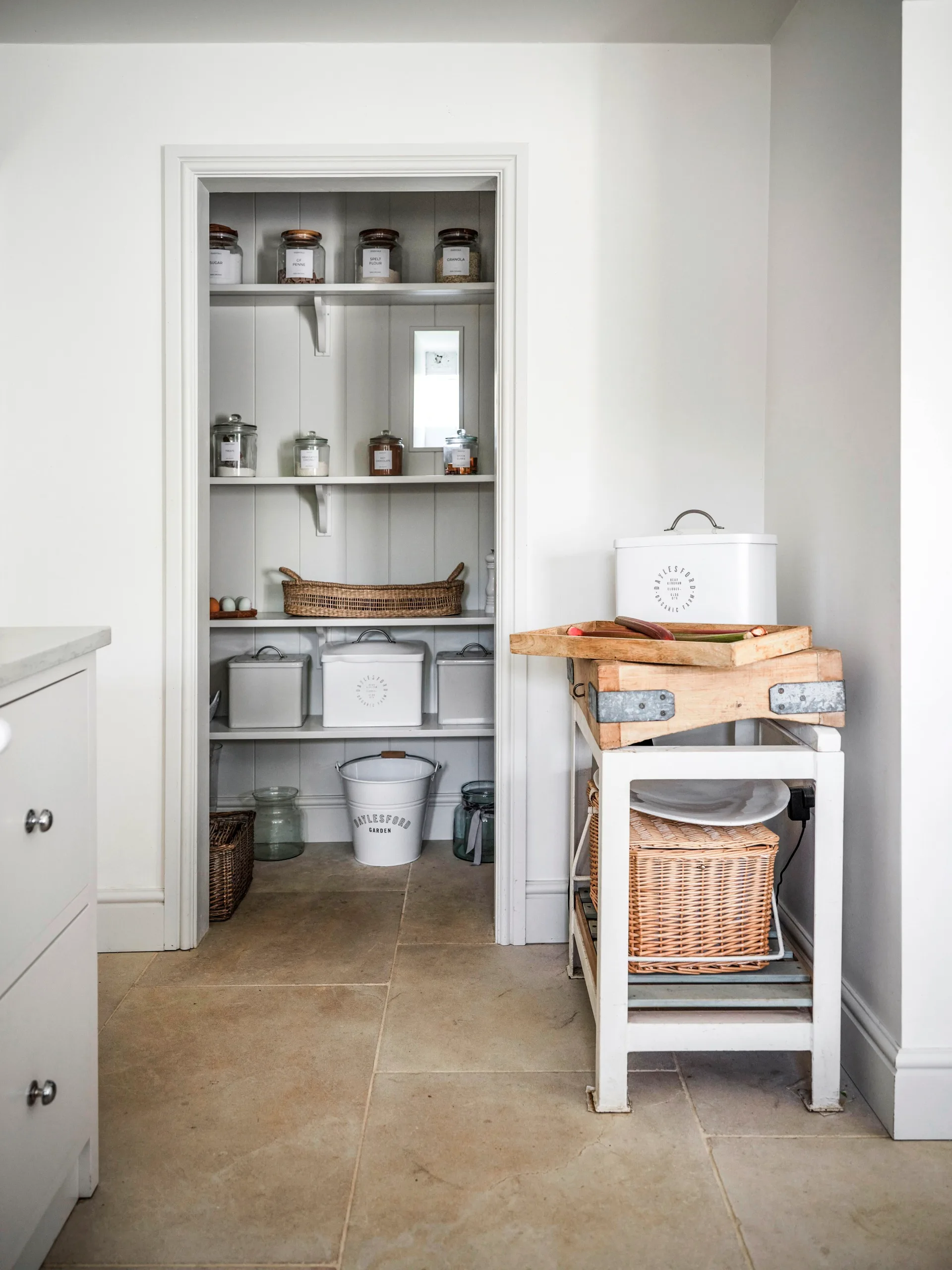 A pantry with panelled walls and shelving.