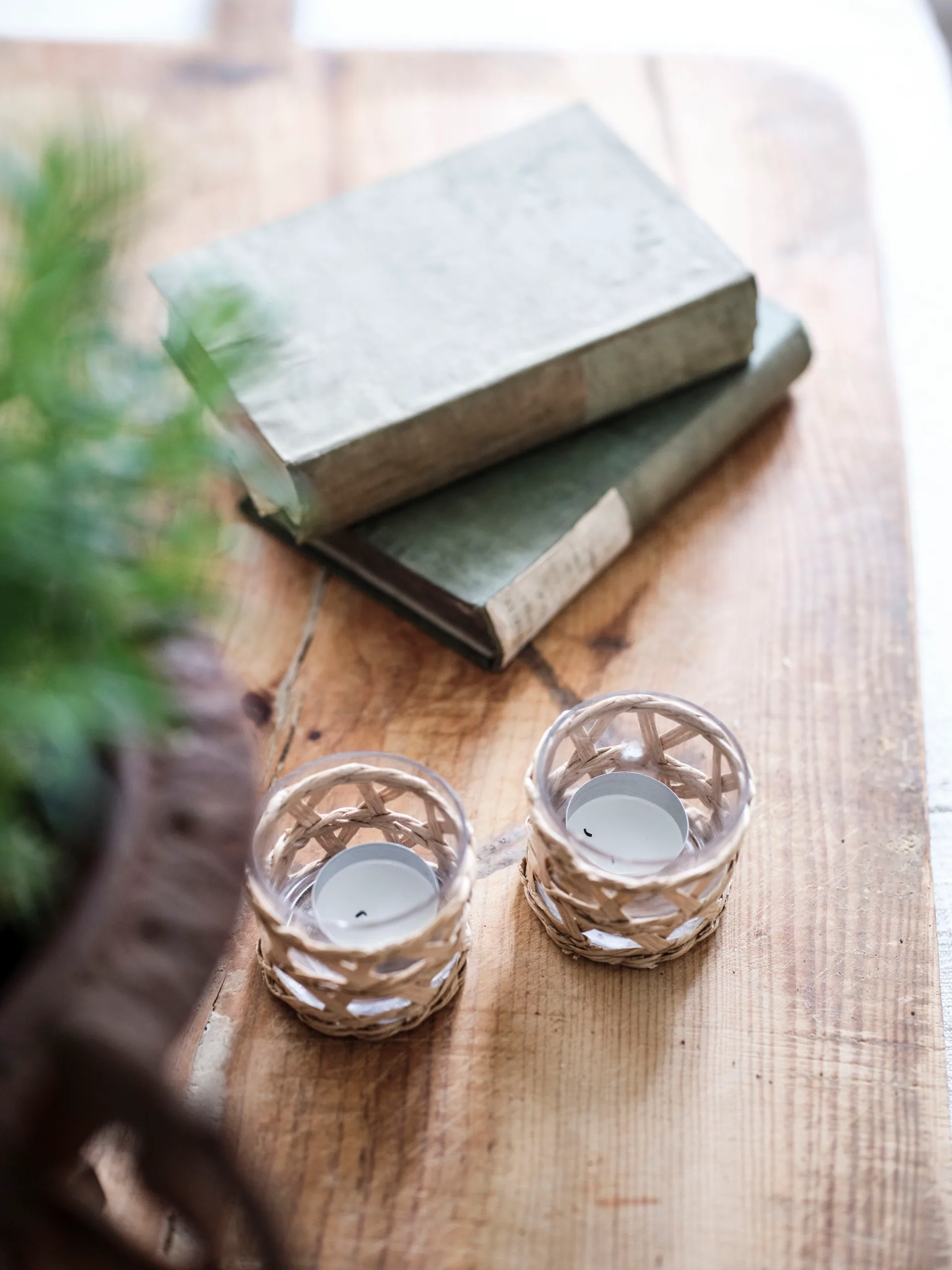 Antique books and candle holders sitting on a sideboard.
