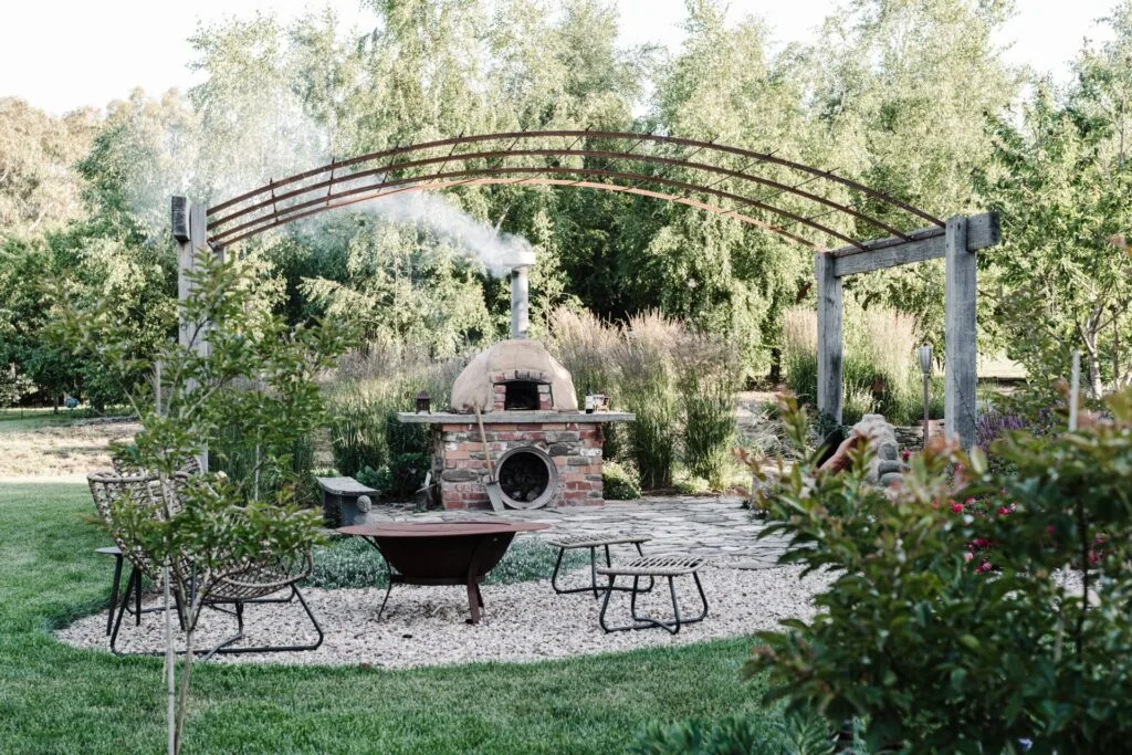 A reclaimed brick outdoor fireplace in a garden.