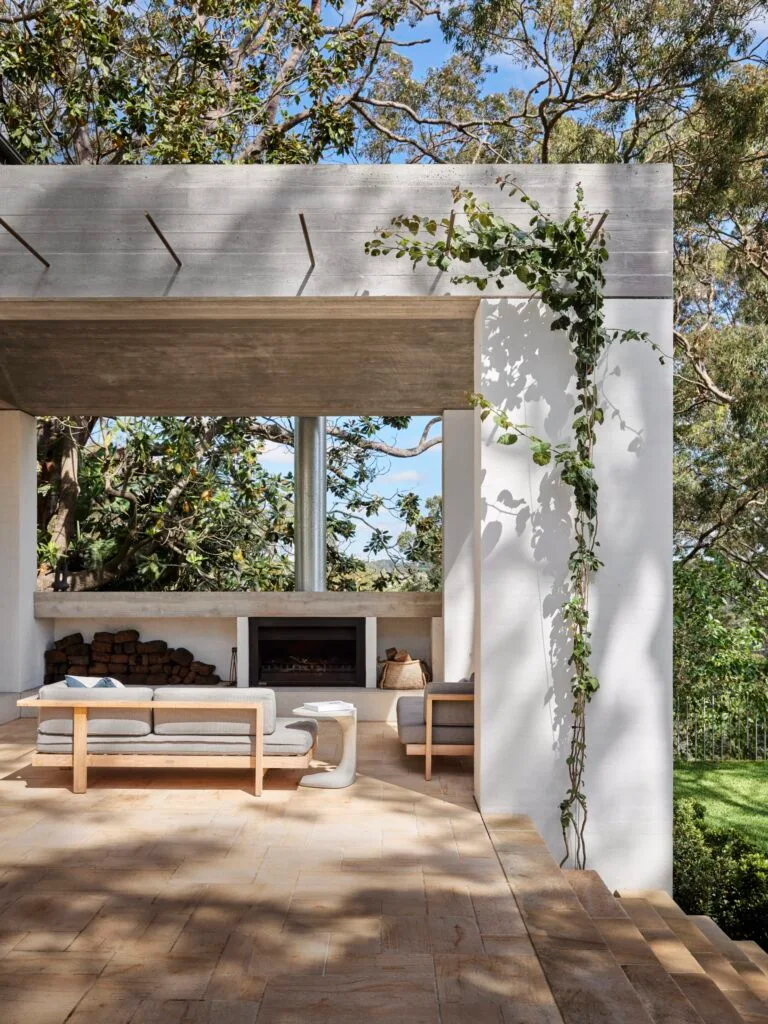 A stone outdoor entertaining pavilion with a wood burning fireplace.