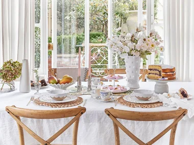 Mothers Day Decorating Table With Flowers Candles Cake and Dinnerware