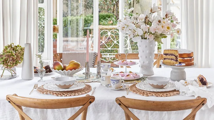 Mothers Day Decorating Table With Flowers Candles Cake and Dinnerware