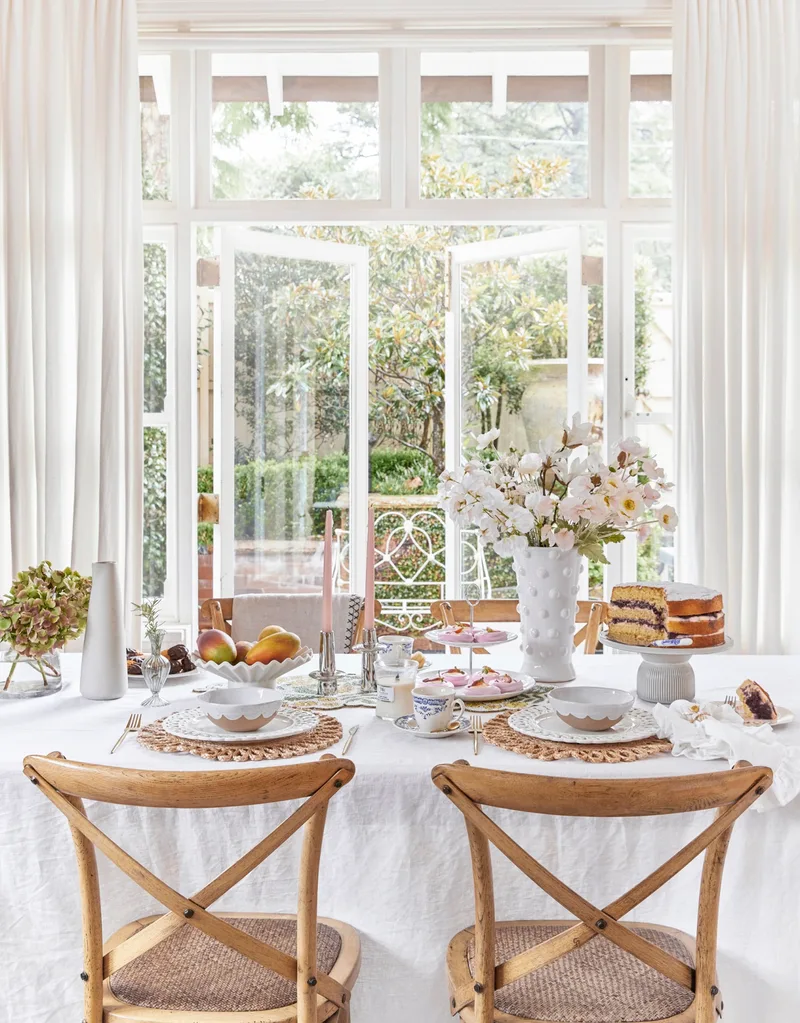 Mothers Day Decorating Table With Flowers Candles Cake and Dinnerware