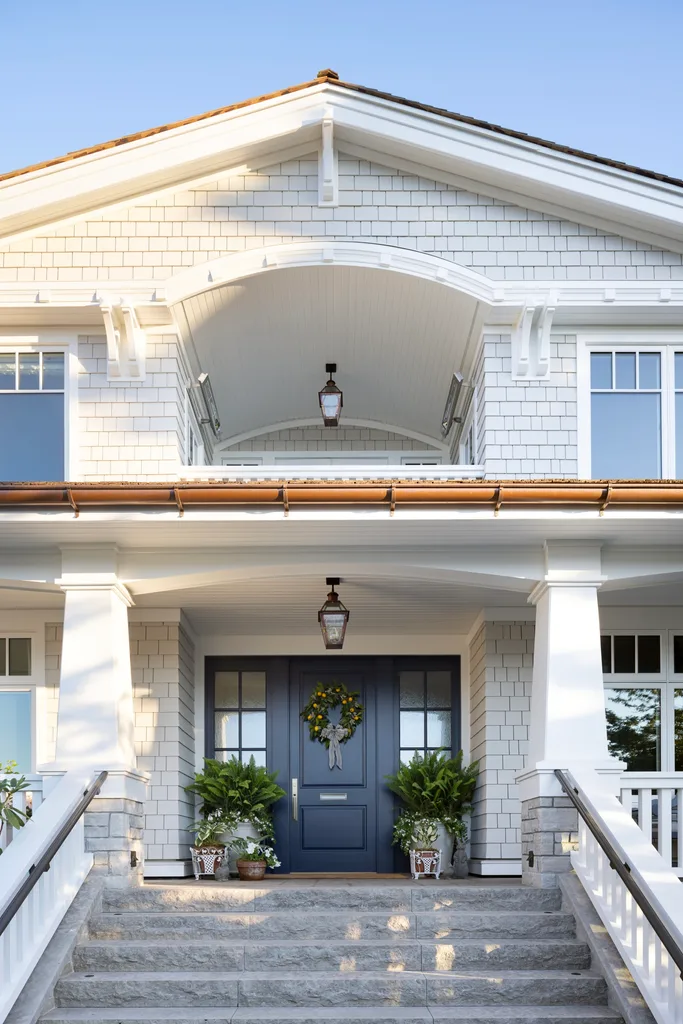 A two-storey, white stone exterior with a blue door.