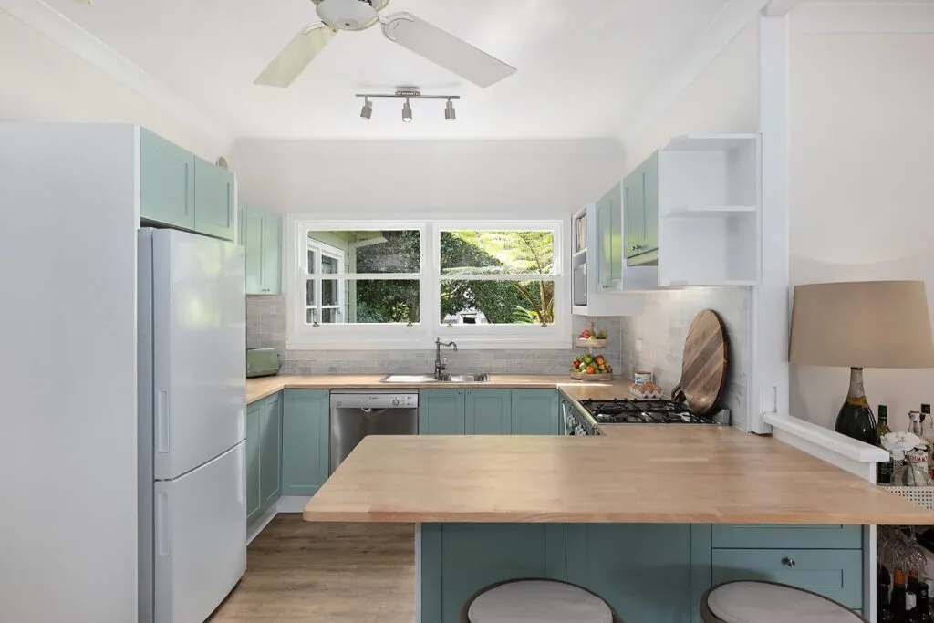 Country coastal style teal kitchen at a property owned by Charlie Albone and Juliet Love in Ourimbah, NSW.