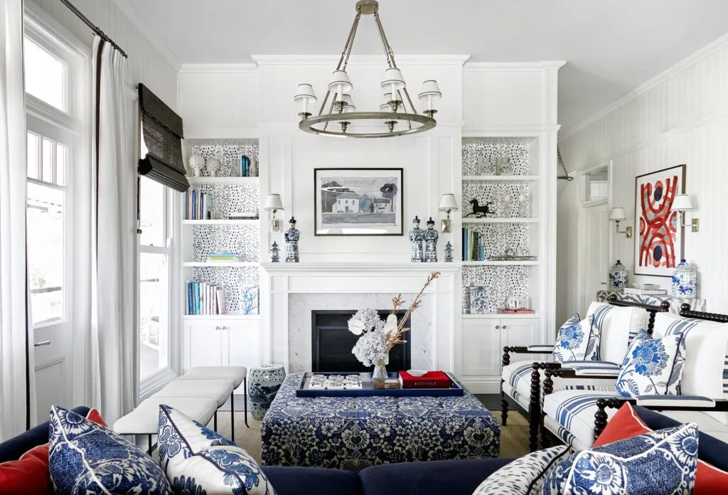 An American-style living area with patterned blue sofas, a fireplace and white wall panelling.