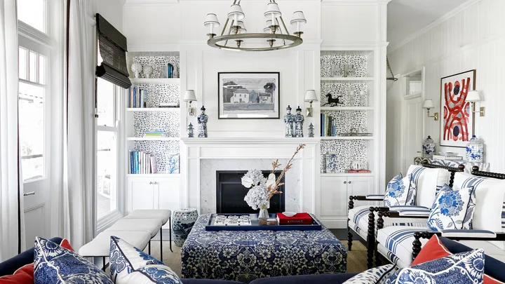 An American-style living area with patterned blue sofas, a fireplace and white wall panelling.