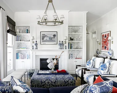 An American-style living area with patterned blue sofas, a fireplace and white wall panelling.