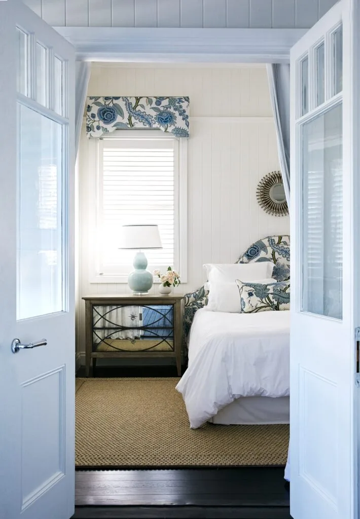 Doors opening into the main bedroom with blue floral accent decor.