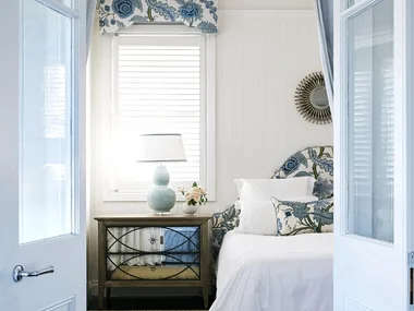 Doors opening into the main bedroom with blue floral accent decor.