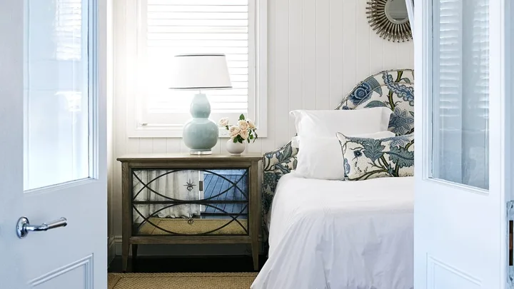 Doors opening into the main bedroom with blue floral accent decor.