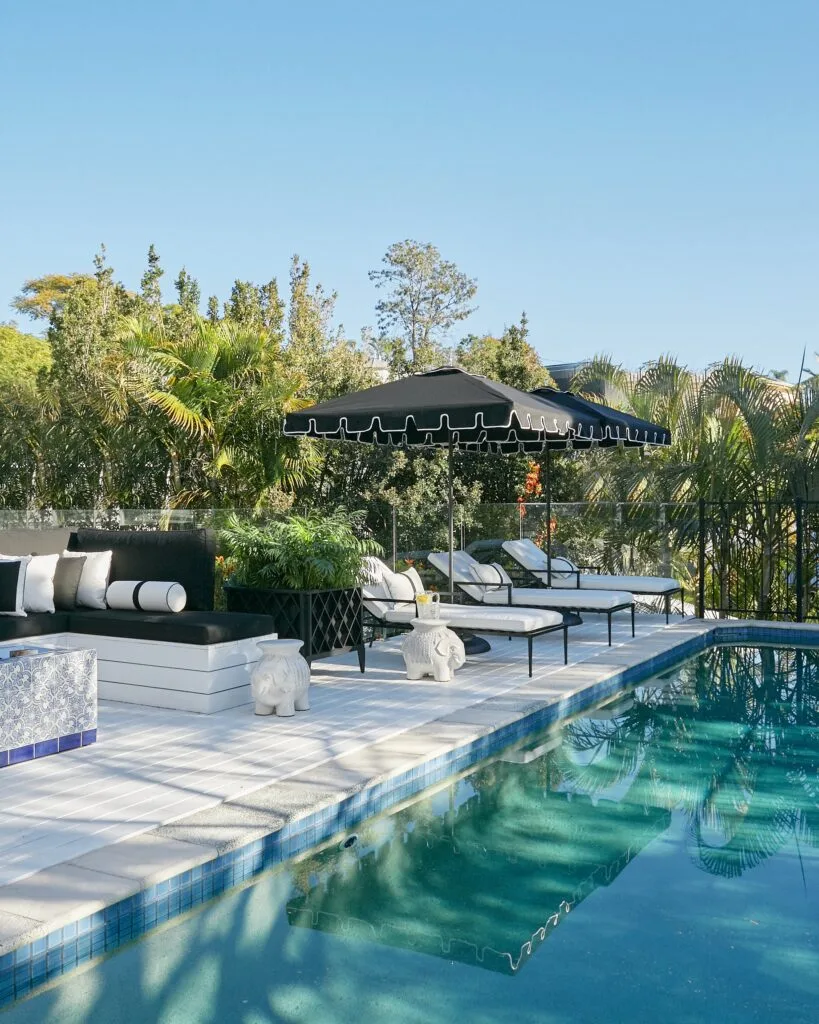 The pool area with loungers and black parasols.