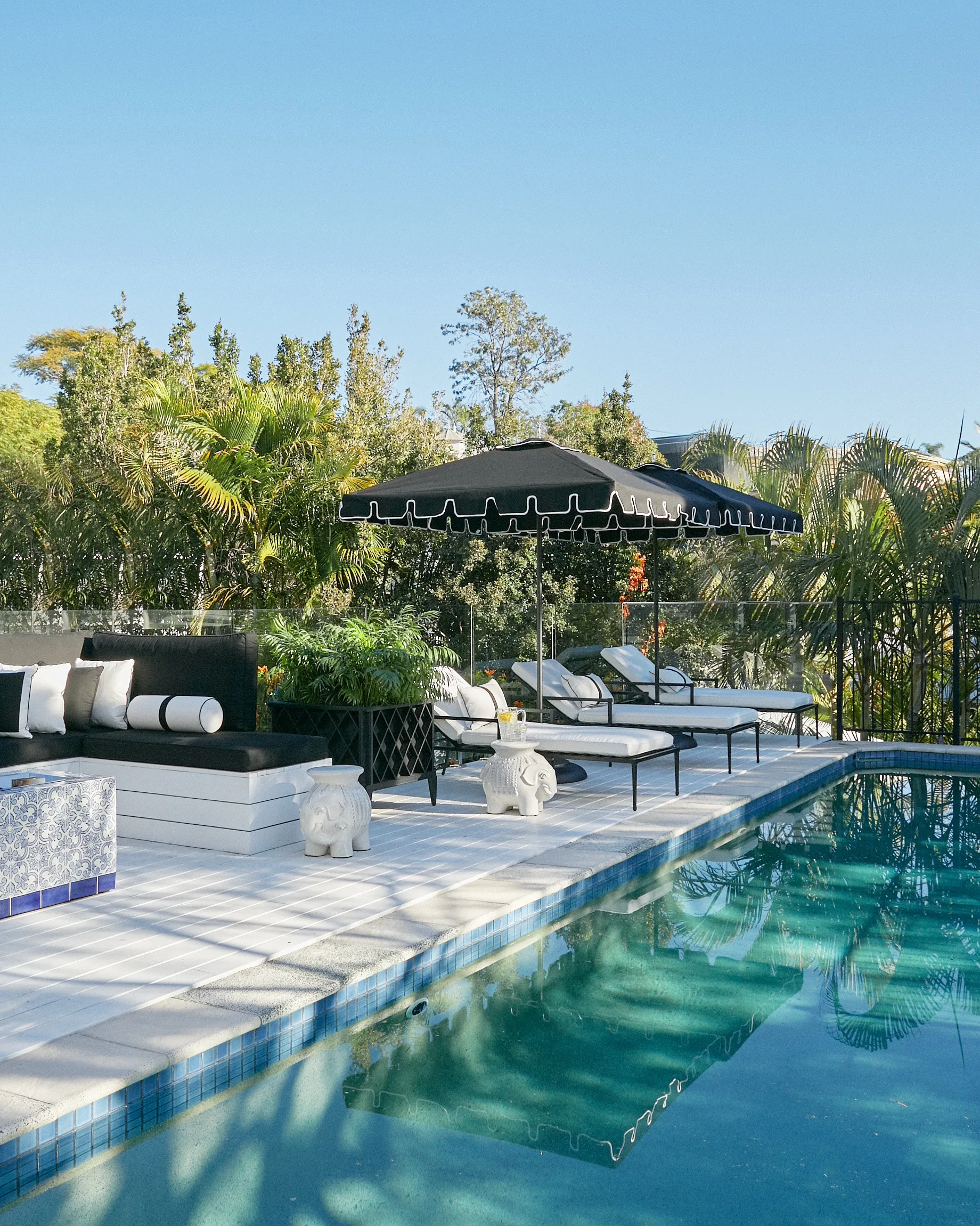 The pool area with loungers and black parasols.