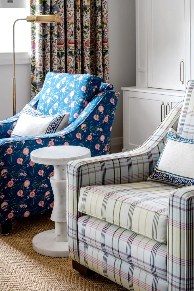 A pair of floral and tartan patterned armchairs.