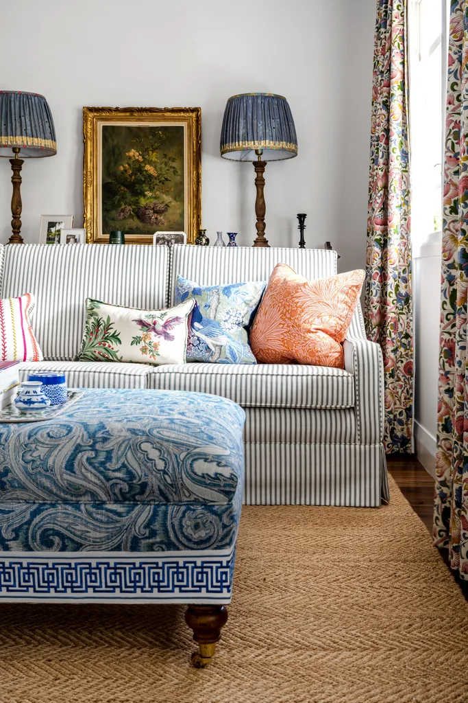 A striped sofa with a paisley ottoman and vintage table decor.