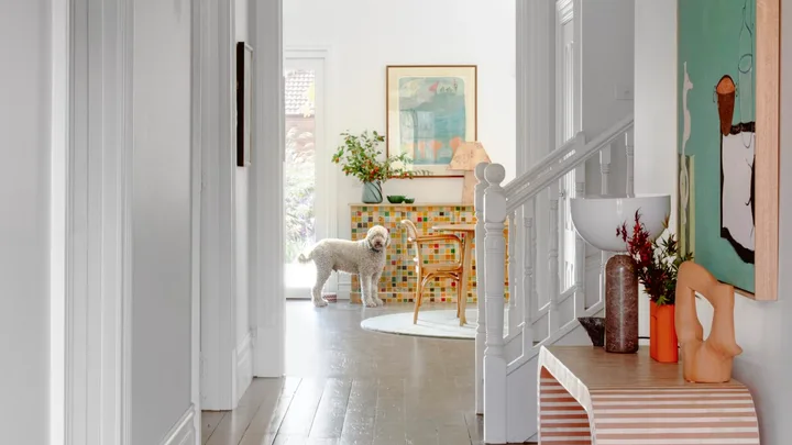 A heritage style hallway with decorative fretwork and a red hallway runner.