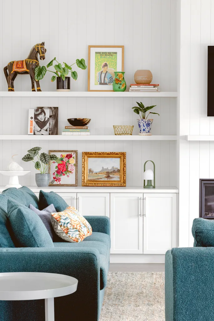 Open shelving decorated with picture frames and colourful souvenirs.