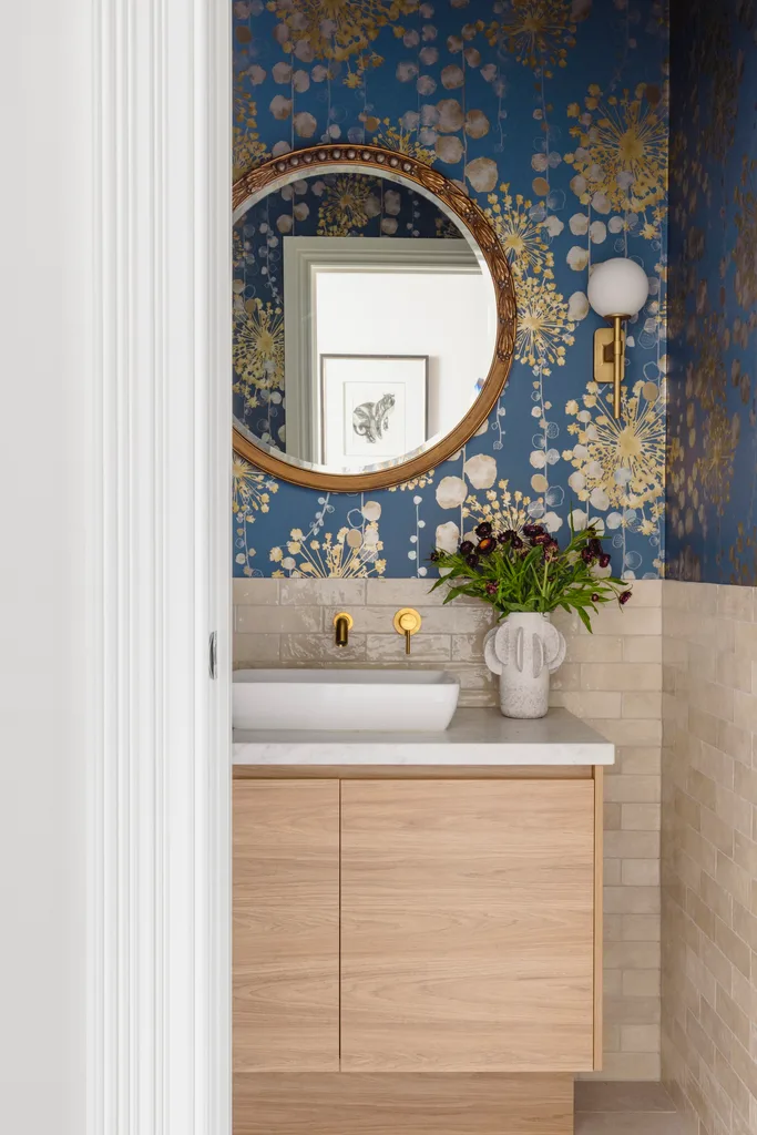 A powder room with blue and gold wallpaper and a timber vanity.