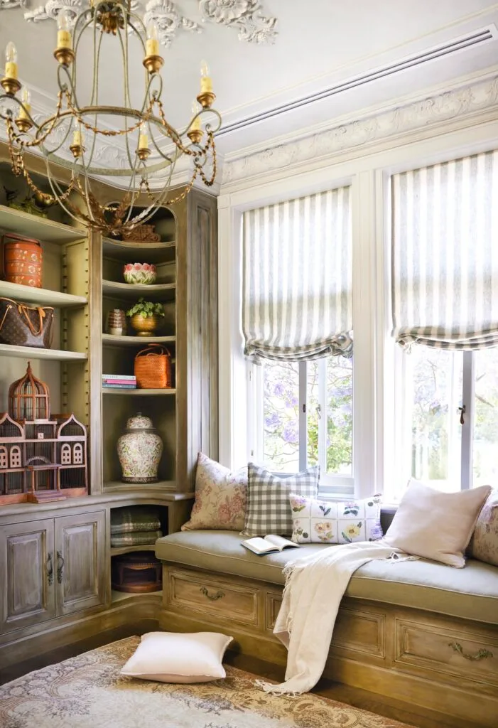 A window seat, open shelving and a rustic chandelier.