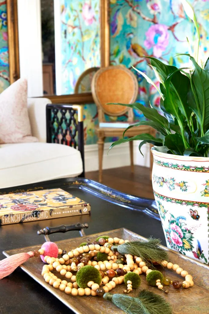 A coffee table with a decorative tray, book and planter.