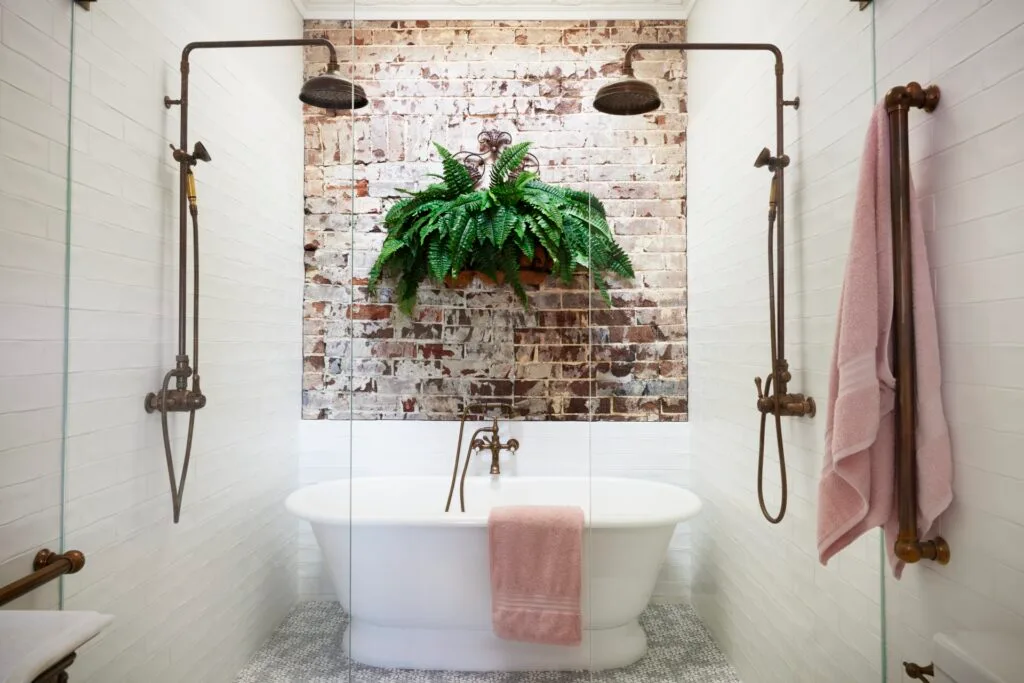 A rustic style ensuite with a freestanding bath and double shower.