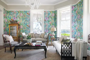 A formal living room with blue bird wallpaper and French furniture.